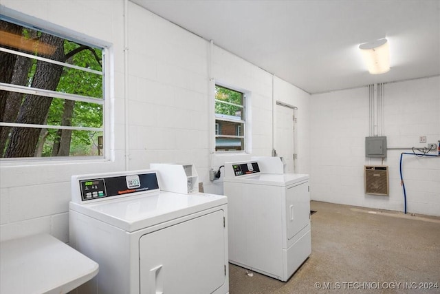 washroom with washing machine and clothes dryer, heating unit, and electric panel