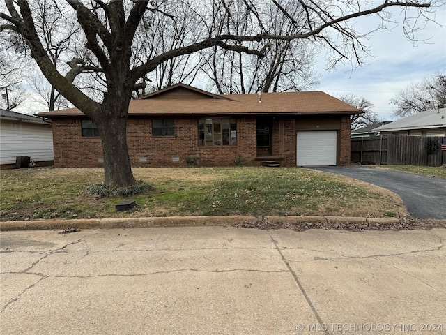 single story home with a garage and a front lawn