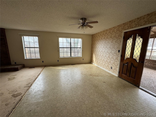 entrance foyer with tile floors, plenty of natural light, ceiling fan, and a textured ceiling