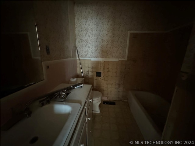 full bathroom featuring tile flooring, tile walls, large vanity, toilet, and bathing tub / shower combination