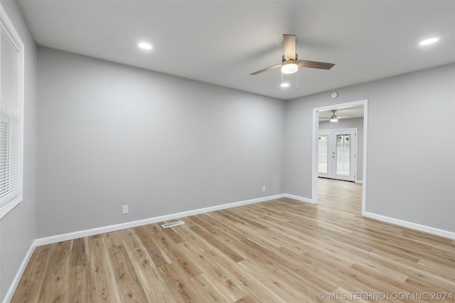 empty room featuring light wood-style floors, recessed lighting, french doors, and baseboards