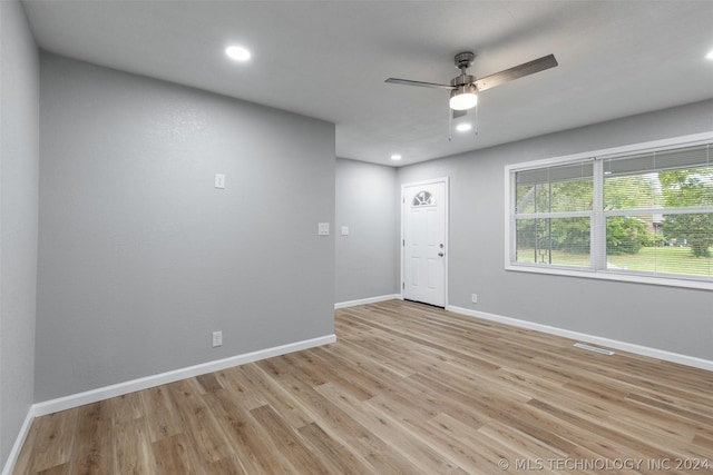 empty room with light wood finished floors, ceiling fan, visible vents, and baseboards