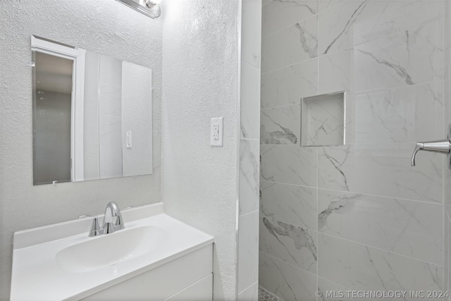 bathroom with vanity and a textured wall