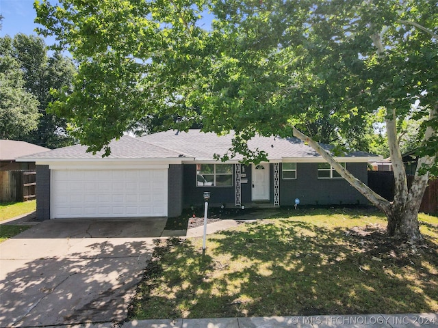 ranch-style home with driveway, brick siding, a front lawn, and an attached garage