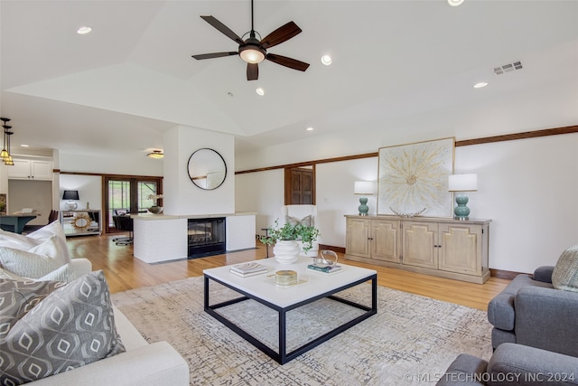 living room featuring lofted ceiling, light wood-type flooring, and ceiling fan