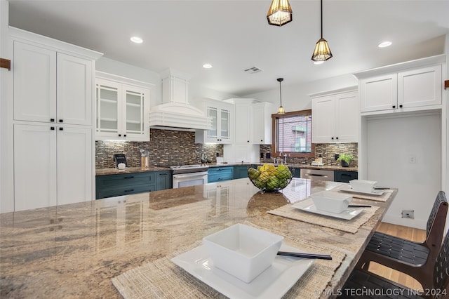 kitchen featuring white electric stove, a kitchen breakfast bar, custom exhaust hood, pendant lighting, and white cabinets