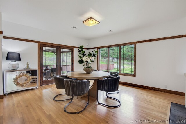 dining space with french doors and light hardwood / wood-style floors