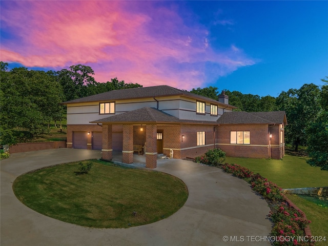 prairie-style house featuring a garage and a lawn