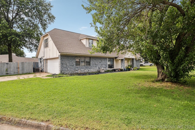 view of front facade featuring a garage, central AC, and a front yard