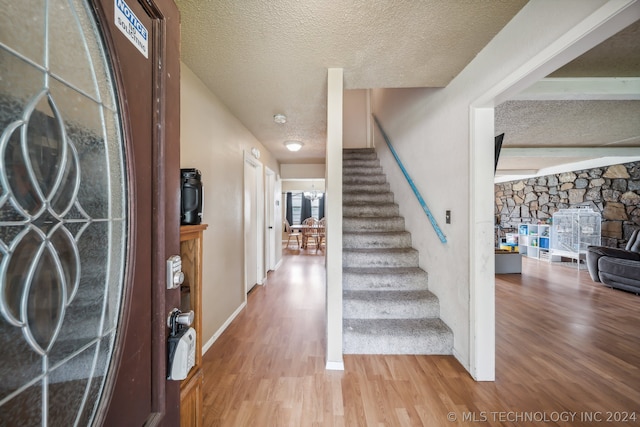 foyer with hardwood / wood-style flooring and a textured ceiling