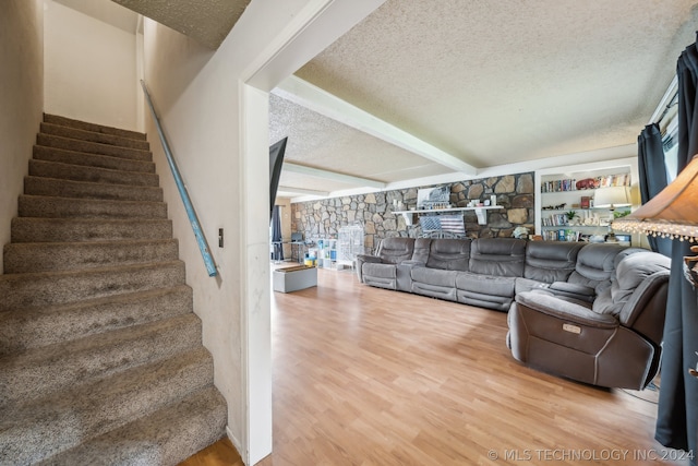 living room with beam ceiling, a textured ceiling, and hardwood / wood-style floors