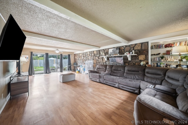 living room with beamed ceiling, wood-type flooring, a textured ceiling, and ceiling fan