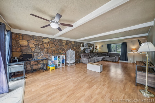 living room with light hardwood / wood-style floors, a textured ceiling, ceiling fan, and beamed ceiling