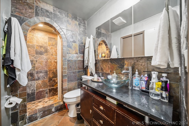 bathroom with vanity, walk in shower, tile walls, toilet, and tile patterned flooring