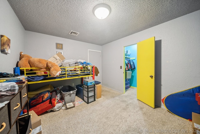 carpeted bedroom featuring a closet and a textured ceiling