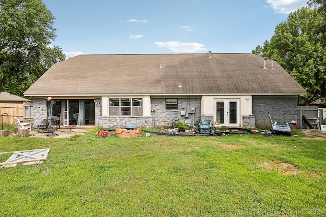 back of property with french doors, a patio area, and a lawn