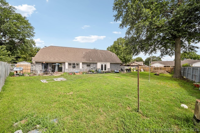 rear view of house featuring a yard and a patio area