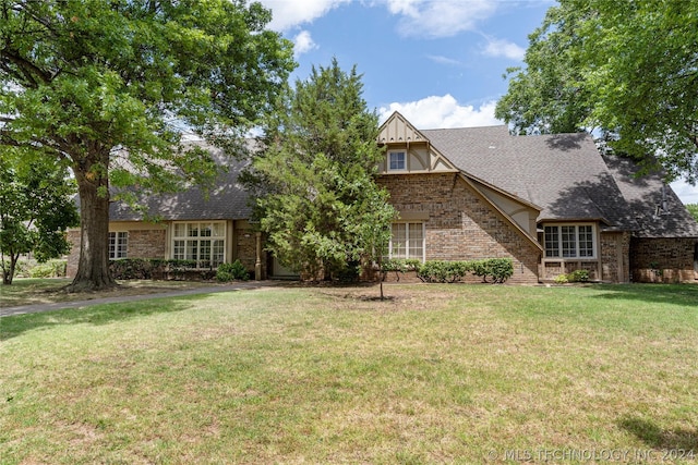 tudor-style house featuring a front lawn