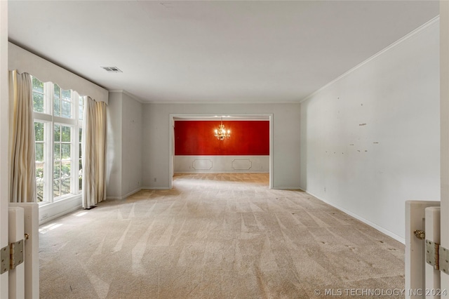 carpeted empty room with ornamental molding and a notable chandelier