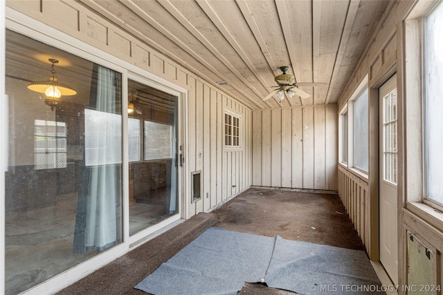 sunroom featuring ceiling fan and wood ceiling