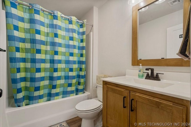 full bathroom with hardwood / wood-style flooring, vanity, shower / bath combination with curtain, and toilet