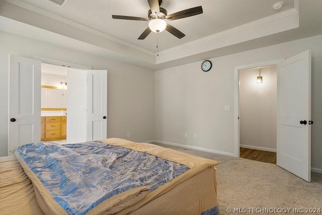 carpeted bedroom featuring crown molding, ceiling fan, a raised ceiling, and ensuite bath