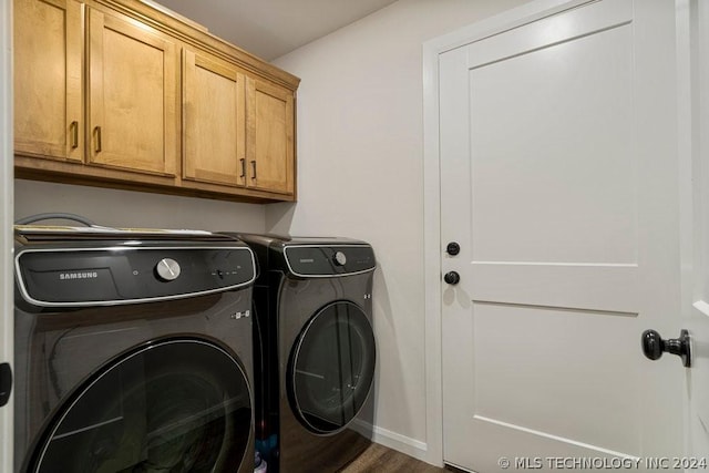 laundry area with cabinets, hardwood / wood-style flooring, and washer and dryer