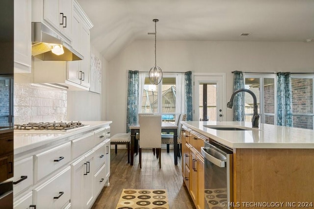 kitchen with tasteful backsplash, white cabinets, hanging light fixtures, a kitchen island with sink, and stainless steel appliances