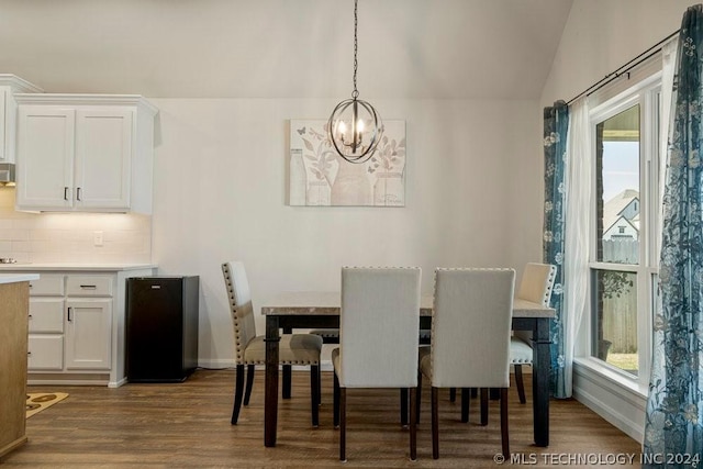 dining area featuring an inviting chandelier, lofted ceiling, and wood-type flooring