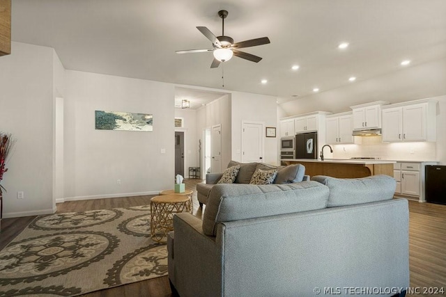 living room with ceiling fan, lofted ceiling, dark hardwood / wood-style flooring, and sink