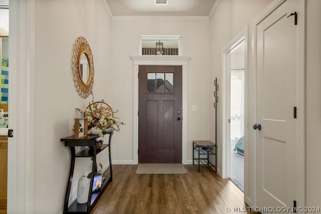 foyer entrance with wood-type flooring and crown molding