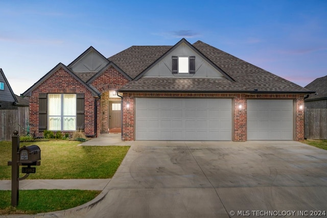 view of front of property featuring a garage and a lawn