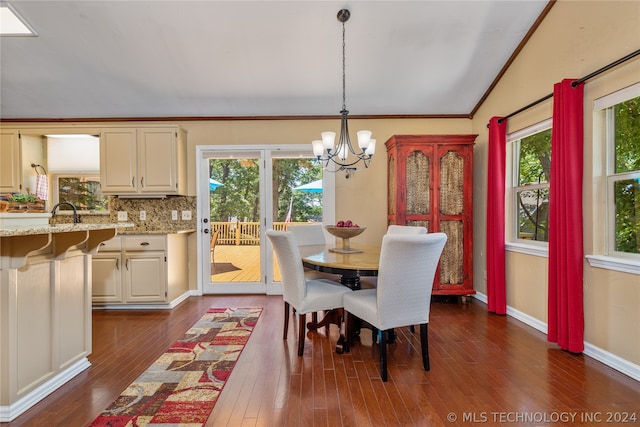 dining area featuring crown molding, dark wood-type flooring, vaulted ceiling, and an inviting chandelier