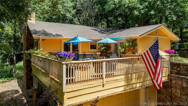 back of house featuring a garage and a wooden deck