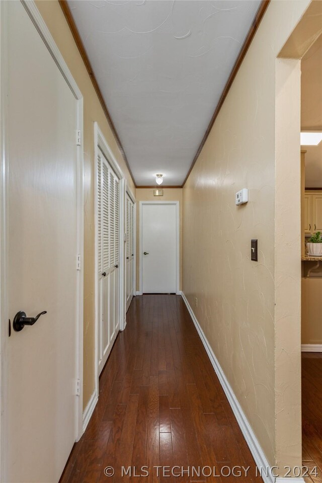 corridor with crown molding and wood-type flooring