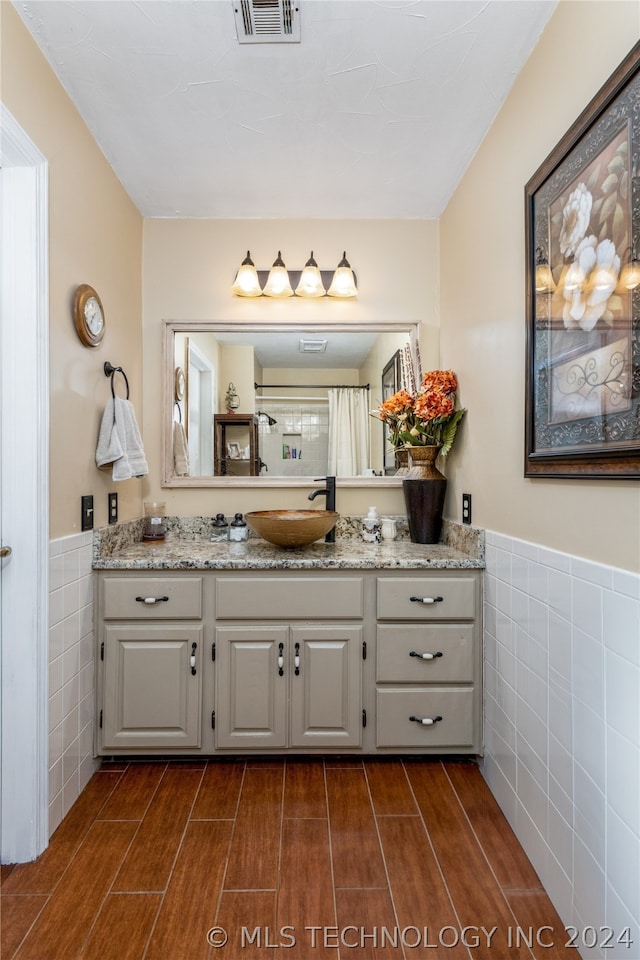 bathroom featuring vanity and tile walls