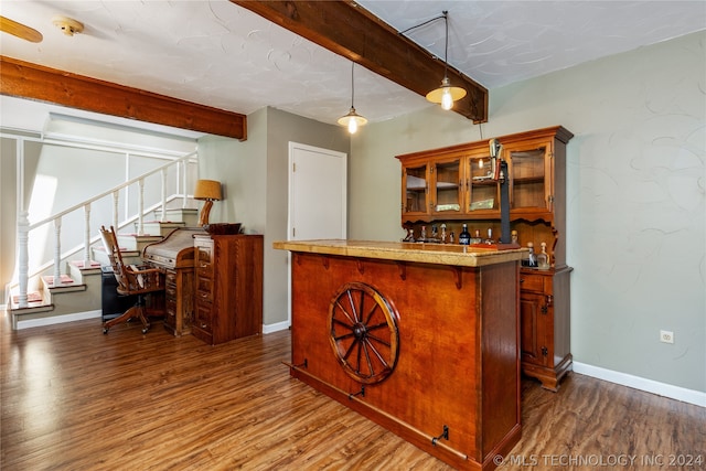 bar with dark hardwood / wood-style floors, beamed ceiling, and pendant lighting