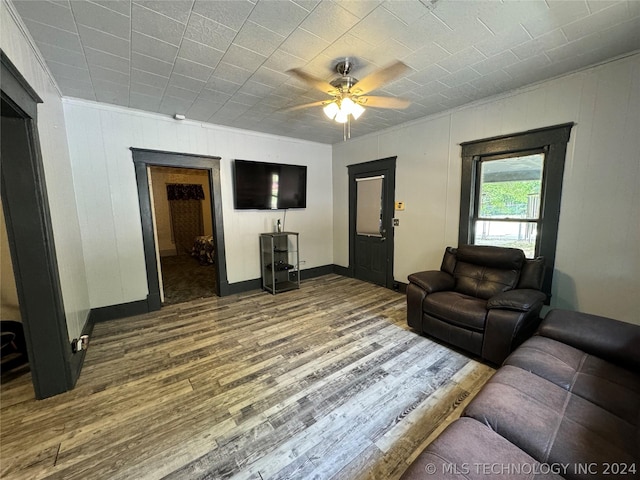 living room with hardwood / wood-style floors, ceiling fan, and crown molding