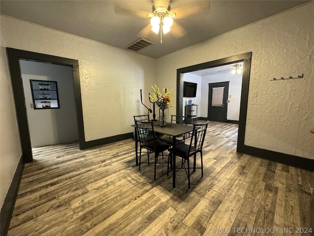 dining space with wood-type flooring and ceiling fan