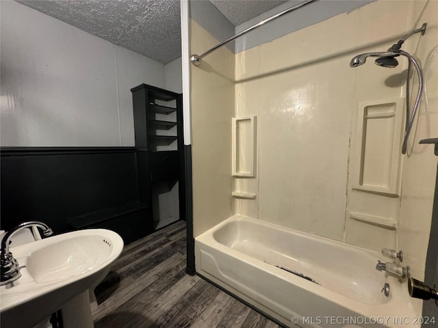 bathroom with sink, shower / bath combination, a textured ceiling, and hardwood / wood-style flooring