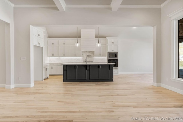 kitchen featuring white cabinetry, hanging light fixtures, backsplash, stainless steel appliances, and an island with sink