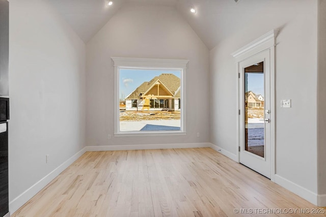 unfurnished dining area with lofted ceiling and light hardwood / wood-style flooring