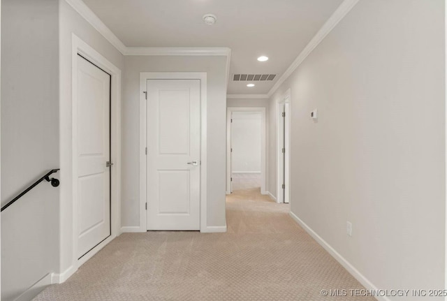 hallway with crown molding and light colored carpet