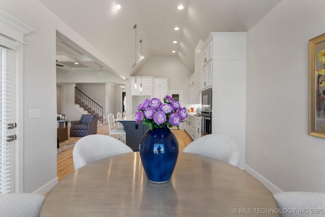 dining space with light wood-style floors, recessed lighting, baseboards, vaulted ceiling, and stairway