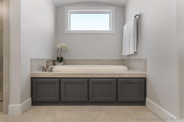 full bathroom featuring a garden tub, baseboards, walk in shower, and tile patterned flooring