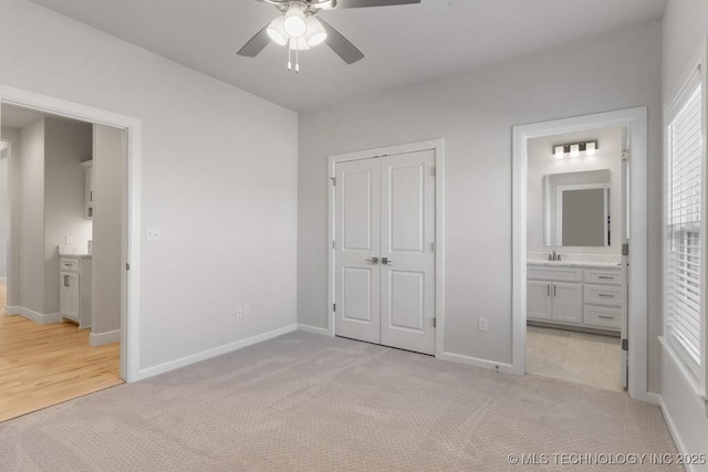 unfurnished bedroom with a sink, baseboards, light carpet, and a closet