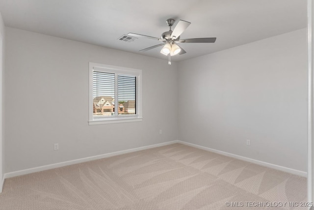 spare room featuring baseboards, ceiling fan, visible vents, and light carpet