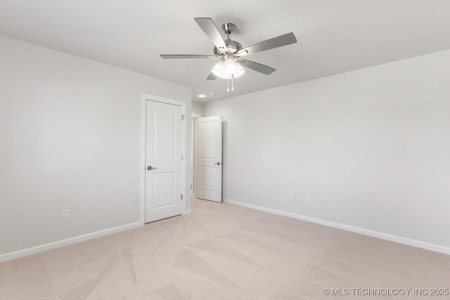 unfurnished room featuring a ceiling fan, baseboards, and light carpet
