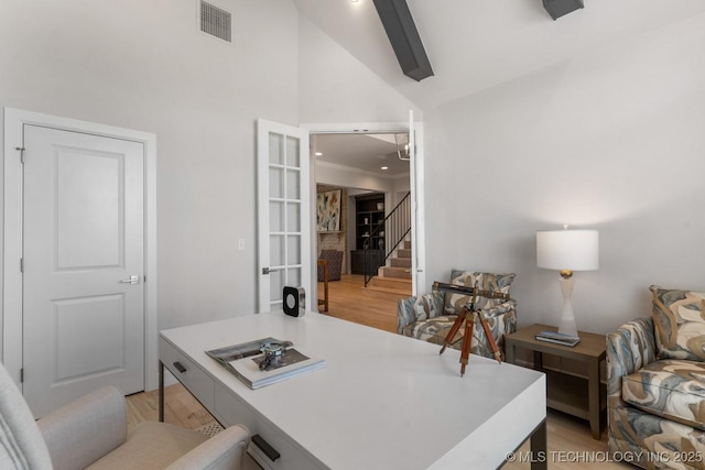 office featuring light wood-style floors, high vaulted ceiling, french doors, and visible vents