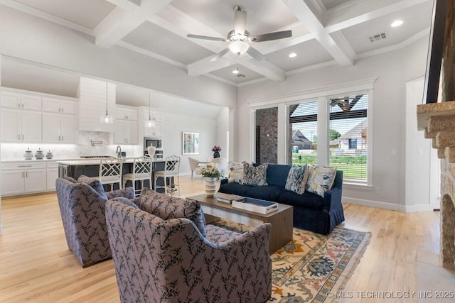 living room featuring light wood-style floors, visible vents, beam ceiling, and coffered ceiling